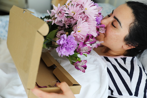 mother sniffing flowers on mothers day